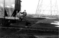 The Backworth shunter uses his pole to hitch a ride as the 0-6-0ST propels hoppers round the 'new curve'. For obvious reasons this practice was officially frowned upon even in less safety conscious days. I remember this man could have doubled for the actor Talfryn Thomas (Mr. Cheeseman in Dad's Army) although I'm sure his accent would have been completely different. <br><br>[Mark Bartlett //1975]