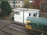 Freightliner Heavy Haul 66605 draws up at Great Rocks Junction signal box, where the driver had a conversation before taking his train of empty hoppers into the Tunstead quarry complex. The box has been substantially rebuilt but still operates traditional semaphores and point mechanisms.  <br><br>[Mark Bartlett 23/10/2009]