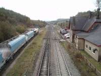 A view south towards Great Rocks along the former main line to Derby at Peak Forest, showing the signal box and associated sidings. The former station building, closed in 1967, has been extended and is now an area office for DBS. 66041 is shunting empty hoppers into the Peak Forest quarry sidings.  <br><br>[Mark Bartlett 23/10/2009]