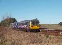 With the Royal Lytham St. Annes championship golf course behind the train, Pacer 142015 leaves the former island platform at Ansdell and Fairhaven on a Northern service heading for Blackpool South in February 2009. Ansdell is one of six intermediate stations on the 12 mile branch.<br><br>[Mark Bartlett 07/02/2009]