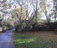 The NBR North Leith Branch, now a walkway, looking towards the terminus on 31 October 2009. A little behind me was Bonnington station, still substantially intact. Through the fence to the right ran the goods lines serving the once industrial Bonnington area, split in two by the Water of Leith which the lines crossed. There was a goods station at the start of the branch, then lines fanned out into a dense pattern serving tanneries, ironworks and the like. At one point a line formed a tight figure 4; presumably worth all the required reversing in a pre-motor age. <br>
<br><br>[David Panton 31/10/2009]