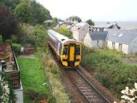 Having cleared the bridge carrying the A862, the 0812 Wick - Inverness train runs past the deserted beer garden at the rear of the Clachnaharry Inn on 3 October as it approaches the swing bridge over the Caledonian Canal. With the chill wind and driving rain off the Beauly Firth, it was only the continuing thought of eventually taking a comfy seat near the warm fire in the bar that made this picture possible.  <br>
<br><br>[John Furnevel 03/10/2009]