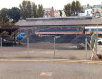 View across a coal yard. Locomotive 47566 and its train, resplendent in BR <I>InterCity</I> livery, stabled alongside the old NER locomotive shed at Whitby in July 1993, having worked in on an excursion. <br><br>[David Pesterfield /07/1993]