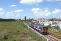 Looking west from Watkin Lane, Lostock Hall, on 14 June 2009 as a Northern DMU heads for Preston with a Colne - Blackpool South service. What is now wasteland on the left of the picture is the site of the former Lostock Hall (10D) shed, one of the last outposts of steam on the BR network. Officially closed on 5 August 1968, the building continued to be used by British Rail Engineering for a further 20 years before being finally demolished in 1990.<br><br>[John McIntyre 14/06/2009]