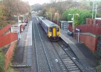 A Clitheroe to Manchester Victoria service calls at Ramsgreave and Wilpshire, a station that only opened when services to Clitheroe resumed in 1987. It is better sited for the local population than the original Wilpshire station, closed in 1962, which is the white building in the distance, [See image 19311] now a private residence.  <br><br>[Mark Bartlett 17/11/2009]