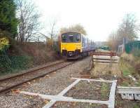 A Clitheroe to Manchester service, with 150149, draws past the now defunct sand drag at the foot of the gradient from Ramsgreave. The train runs over the short single line section through closed Daisyfield station to join the East Lancashire line at Daisyfield Junction. The old sand drag, which stems from the days when unfitted freights were diverted away from the electrified WCML to run via the Settle and Carlisle, is piled high with concrete sleepers in readiness for Sunday engineering work.<br><br>[Mark Bartlett 17/11/2009]