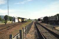 Cl 47 no 47674 passes Aviemore SB on a summer morning in the early 1990s as <I>The Royal Scotsman</I> stands at Aviemore Speyside. In the right foreground the catch points have been clamped to allow the train to be shunted onto BR metals since the Class 37 from Inverness has not arrived to take the train south.  <br><br>[John McIntyre 05/07/1991]