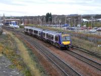 170 401 leaves Kirkcaldy with the hourly Edinburgh to Dundee semi-fast service on Saturday 21 November. Behind it lies the now indespensible car park, full of commuters' cars during the week, which was built a few years ago on the land once occupied by the extensive goods yard. The few terminating trains, when needing to clear the main line, use the siding which starts under the rear coach. <br>
<br><br>[David Panton 21/11/2009]