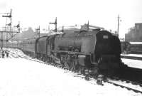 A neglected looking <I>Coronation</I> Pacific pulls into Edinburgh's Princes Street station in the winter of 1963 at the head of a lengthy rugby special from Wales for the February 2nd international at Murrayfield stadium. Wales won the match 6-0, their only victory in that year's Five Nations Championship, in which they collected the 'wooden spoon'.<br>
<br><br>[Frank Spaven Collection (Courtesy David Spaven) //1963]