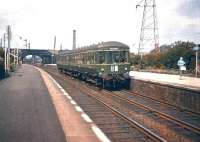 A Waverley - Musselburgh DMU photographed at Joppa in the Summer of 1958. Notable features include the bridge support, visible through the arch of the road bridge, which carries the former Lothian Lines over the ECML; Portobello yard, part of which is visible beyond the bridge; the chimney of the BR laundry standing above the centre of the DMU and the compact signal box squeezed between the road bridge and the station footbridge. [See image 14164] <br>
<br><br>[A Snapper (Courtesy Bruce McCartney) 14/06/1958]