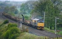 A <I>Dutch</I> liveried Class 31 hauls a rake of engineers' wagons, as they were called before the days of infrastructure trains, along the Up WCML just south of Oubeck Loops, which can just be seen behind the train. The signal controls the access to the Down loop.<br><br>[Mark Bartlett //1990]