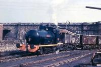 0-6-0F <I>Lancaster</I> shunting 16 ton mineral wagons at Lancaster Power Station. Behind the wall is the Lancaster to Wennington line, cut back to this point by that time, and behind that Rennie's aqueduct carrying the Lancaster Canal over the River Lune. The aqueduct is still in use but the rest of the infrastructure in this picture has now gone, as have the other power station sidings on the north side of the canal embankment. <I>Lancaster</I> itself, Andrew Barclay 1572 of 1917, later worked for a time at Heysham Nuclear Power Station but is now in store unrestored at WCRC Steamtown Carnforth. [See image 49994]<br><br>[David Hindle //1968]