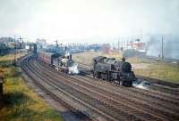 A busy scene at Gourock on Friday 4 September 1959, with a pair of steamers berthed at the pier alongside the station and Caley <I>Jumbo</I> 0-6-0 no 57416 off Ladyburn shed moving a train of empty stock. Meantime, one of Polmadie's Standard class 4 2-6-4Ts no 80058 reverses towards the station, where it will take out the next train to Glasgow. <br><br>[A Snapper (Courtesy Bruce McCartney) 04/09/1959]