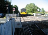 An Ormskirk to Preston service in the hands of Class 142 012 departs from Rufford over the level crossing on the almost dead straight section of track towards Croston on 25 June 2008.<br><br>[John McIntyre 25/06/2008]