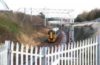 Having restarted from Livingston North and passed below Deans Road North bridge, the 1054 Bathgate - Waverley service heads east through the metalwork towards its next stop at Uphall on 27 November.<br><br>[John Furnevel 27/11/2009]