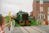 The resident diesel-hydraulic shunter with single coach crossing the entrance road to the Snibston Discovery Centre and colliery museum.  A certain website with multiple maps sadly can't tell me the name of this road. Nor do its aerial pictures show the houses on the right!<br><br>[Ken Strachan 17/05/2009]