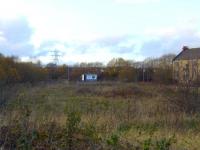 The location of the tram depot in Main Road, Elderslie. Opened in 1904 by Paisley District Tramways, it was acquired by Glasgow City Transport in 1923. It was also used as as bus garage between 1932 and 1955 and eventually closed in 1957. The site has been unused for a number of years. Behind the advertising hoarding in the centre of shot is the Glasgow, Paisley, Kilmarnock and Ayr Railway, to the left is the Paisley Canal Line. The photograph is taken from Ferguslie Station on the Paisley and Barrhead District Railway<br><br>[Graham Morgan 15/11/2009]