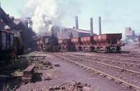 A Barclay 0-4-0ST, probably No. 1, bustles about the foundry with internal user hopper wagons on the last day of operations at Millom Ironworks in 1968. On the left a John Fowler diesel shunter busies itself with a rake of 16 tonners. After the works closed later that year all trace of the industry was quickly swept away, although the three diesel locomotives went to Workington Docks where they survived for a further forty years.<br><br>[David Hindle 19/09/1968]