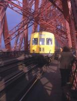 A sight one couldn't see nowadays - for more than one reason! Members of Edinburgh University Railway Society cling somewhat anxiously to the parapet of the Forth Bridge on an official visit in the summer of 1972, as an Edinburgh-bound DMU roars past.<br>
<br><br>[David Spaven //1972]
