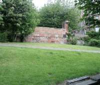 Looking like the remains of a long abandoned ski-jump, the high level bridge abutment at the bottom of Gosford Place, seen here on 18 July 2009, stands as a memorial to the Caledonian Railway's 'Leith New Lines'. Inspired by the opening of Leith's 54 acre <I>Edinburgh Dock</I> in 1881 the route from Newhaven Junction was opened in 1903, having reached its goal via all manner of urban embankents, viaducts and bridges. Neither the original plans nor the projected traffic were ever realised, three partially completed passenger stations were never opened  and the route was singled after 14 years. Closure between Newhaven and Leith Walk came in January 1966. The photograph is taken from the trackbed of the North Leith branch just west of the former Bonnington station. [See image 28071]  <br>
<br><br>[John Furnevel 18/07/2009]