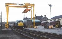 A 1977 view showing the westward expansion and modernisation of Elgin freight depot following the removal of the platforms (the Class 24 is standing in the former through platform road) after the withdrawal of the Coast and Craigellachie passenger services in 1968. For the next 25 years Elgin served as a major railhead for whisky, military equipment, oil and general freight traffic, with a mix of containerised and conventional wagon business.<br><br>[David Spaven //1977]