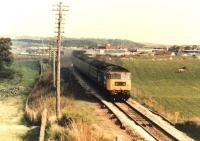 Why do I always think of carrots when I see that name?<br>
What I really like about this picture of an Inverness-bound passenger train is the shape of the fence on the left, which seems to be opening a piece of music. As I recall the large logo 47 was indeed playing a fine song.<br><br>[Ken Strachan /05/1987]