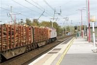 Looking south at Wigan North Western on 15 October 2009 as a Carlisle to Chirk logs train heads up the WCML which curves to the right. To the left (in front of the loco) a Class 156 unit passes on a Manchester to Southport via Wigan Wallgate service.<br><br>[John McIntyre 15/10/2009]