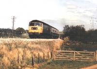 An unidentified class 47 at Kintore in May 1987. The train is approaching the former junction for the Alford branch from the South. I had a fast car and no mortgage. Happy days.<br><br>[Ken Strachan /05/1987]