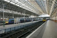 Looking towards the buffers at Manchester Piccadilly on 23 December 2009. On the right in platform 1 is a Northern Rail service for Sheffield via New Mills and the Hope Valley, while on platform 4, a First TransPennine service to Hull is being prepared by coupling together a pair of two-car Turbostars.<br><br>[John McIntyre 23/12/2009]