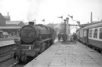 Scene at the east end of Blackburn station on 3 June 1967. The building on the left is part of the old fish dock with the former parcels depot alongside. This has since been demolished and a supermarket car park now overlooks the station [See image 22709]. Black 5 no 45339 is standing on the left, while on the right is the LCGB <I>Thames-Tyne Limited</I>, bound for Carlisle via the S&C, with Britannia Pacific no 70039 <I>Sir Christopher Wren</I> taking on water.<br><br>[Robin Barbour Collection (Courtesy Bruce McCartney) 03/06/1967]