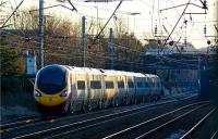 A southbound Pendolino about to pass under Balshaw Lane road bridge as it heads for Wigan North Western on 3 January 2010. The slow lines are curving to the right here prior to entering Euxton Balshaw Lane station while the fast lines continue straight ahead past the station and through Balshaw Lane Junction.<br><br>[John McIntyre 03/01/2010]