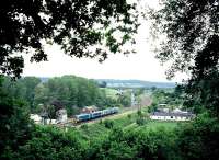 A northbound train passes Pontrilas box (despite the name, just inside England) between Abergavenny and Hereford in the summer of 2008. The sawmill in the middle distance formerly received timber by rail from Scotland, with OTA wagons offloaded in the small yard hidden immediately to the left of the lower quadrant signals.<br><br>[David Spaven //2008]