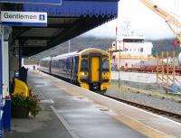 The 1435 for Inverness stands at Kyle on 29 September 2009, with the usual curtain of mist hanging over Skye. On the right a freighter is about to unload wind turbine components onto articulated lorries, which were later seen heading over the Skye bridge with their <I>very wide</I> loads, complete with police escort.<br><br>[John Furnevel 29/09/2009]