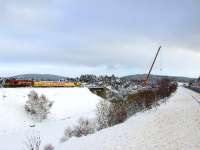 General view of Carrbridge from the A9 on 11 January. EWS 66139 is at the head of an engineers train and the large crane on the right has just lifted a damaged wagon from the station and is lowering it into a holding area.<br><br>[John Gray 11/01/2010]
