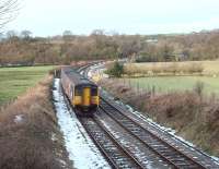 A Morecambe service heads west from Wennington. 150211 curves away from the disused direct line to Lancaster and is heading for Melling Tunnel, which passes under the hill in the background.<br><br>[Mark Bartlett 31/12/2009]