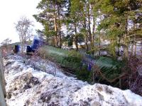 A 'shed' in the back garden. Covered with tarpaulins no 66048 <I> James the engine </I> lives up to the nickname of the Class 66 as it awaits recovery at Carrbridge along with two wrecked container wagons.<br><br>[John Gray 19/01/2010]