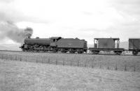 B1 4-6-0 no 61344 has stopped just north of Steele Road in the 1960s with a lengthy Carlisle - Millerhill freight. The rear of the train is standing alongside the platform at Steele Road station where the guard is thought to have been visiting the signal box [see image 26863]<br><br>[Robin Barbour Collection (Courtesy Bruce McCartney) //]