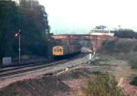 A Northbound DMU (probably for Shrewsbury) has just passed the former junction for Tenbury Wells and Bewdley in September 1988. The road bridge had a sharp left-right kink at this time (now, don't titter), which has since been straightened out at vast expense.<br><br>[Ken Strachan /09/1988]