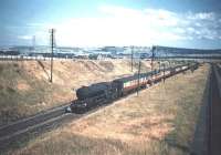 V2 no 60959 on the eastern approaches to Musselburgh with a down train on the ECML in July 1955. The train is about to pass below the bridge carrying Whitehill Farm Road, after which it will run through the site of the modern day Musselburgh station (though that would not be built for another 33 years). On the right are the former freight lines that left the ECML at Monktonhall Junction (in the distance) and ran via Wanton Walls Junction (the direct <I>Lothian Lines</I> route to Leith Docks) through to Niddrie West Junction (and the sub) [See image 4546].<br><br>[A Snapper (Courtesy Bruce McCartney) 16/07/1955]