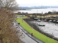 Looking south east over Charlestown Harbour on 24 January with Rosyth Dockyard and the Forth Bridges in the background. The 1894 re-aligned 'main line' followed the path of the grassy verge heading towardsthe site of Charlestown station(1894-1926).<br><br>[Mark Poustie 24/01/2010]