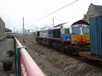 In its now out of date Stobart livery DRS 66411 <I>Eddie the Engine</I> takes a train of Malcolm containers south through Carnforth station. This picture was taken from the cut back Up Main Line platform. All stopping services now use the Furness Line platforms that are only accessible through the subway. <br><br>[Mark Bartlett 26/01/2010]