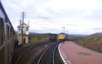 The Thurso branch locomotive waits to detach the rear portion of the incoming Inverness-Wick train at Georgemas Junction in the summer of 1973.<br>
<br><br>[David Spaven //1973]