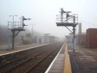 For many years the old Furness Railway locomotive <I>Coppernob</I> resided on the platform at Barrow-in-Furness in a glass building but it was removed during WWII to protect it from the air raids that Barrow experienced and is now part of the NRM National Collection. The January fog masks the functional appearance of the 1960s station buildings in this view looking east. The main semaphores control trains leaving towards Askam and Millom while the shunting arms control access to the carriage sidings. <br><br>[Mark Bartlett 23/01/2010]