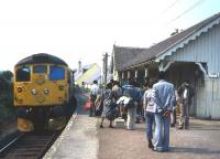 A party of academics and planners from developing countries waits to board the Inverness train at Plockton in the summer of 1983. The 'Plockton seminar' on regional development was an annual event for many years organised by the photographer, originally in his capacity as Head of Planning & Research at the Highlands & Islands Development Board.<br><br>[Frank Spaven Collection (Courtesy David Spaven) //]