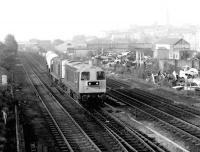 Having just cleared Chesterfield station in May 1980 a northbound freight, hauled by a pair of class 20s, seems to be moving over to the down slow line to avoid the less than attractive car dump. The town's famous <I>twisted spire</I> can just be seen through the haze in the right background.<br><br>[John Furnevel 05/05/1980]