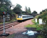 In the days when there was only one station in town a Class 117 <br>
approaches Dunfermline from the north. Shortly afterwards the cascade caused by the introduction of the first Class 170s would see an end to 117s in Scotland. For some time they had been used only on peak time services in Fife and occasionally on the Bathgate line. Note the fixed danger signal, presumably required in connection with Charlestown Junction and its crossover, a little way to the south. <br><br>[David Panton /09/1999]