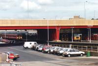 DMUs 155347 & 158810 stand alongside 47640 with mail vans at Bradford Interchange station on 4 August 1992. A release road from the nearest platform runs alongside the fence to the front of the parked cars.<br><br>[David Pesterfield 04/08/1992]