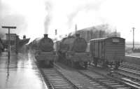 Jubilees in the rain. 45697 <I>Achilles</I> stands at platform 1 of Carlisle station on a thoroughly miserable looking March day in 1961. The locomotive has just taken over the late-running 9.10pm Euston - St Enoch from classmate 45639 <I>Raleigh</I> standing alongside. The train, due away from Carlisle at 5.18am, was photographed on this particulay day with the time approaching 11.9am.<br><br>[K A Gray 30/03/1961]