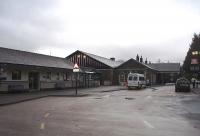 The station forecourt at Windermere in February 2010 showing the modern single storey booking office and the old terminus behind, now tastefully converted into a Booth's supermarket. Buses use the forecourt to connect with trains making the station a useful Lake District interchange.<br><br>[Mark Bartlett 02/02/2010]
