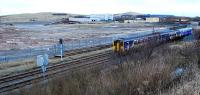 A southbound Sprinter from Carlisle passes the site of the Moss Bay Steelworks which produced rails for over 125 years before production was transfered to Scunthorpe. The works closed in 2006 and have since been demolished.<br><br>[Ewan Crawford 01/02/2010]